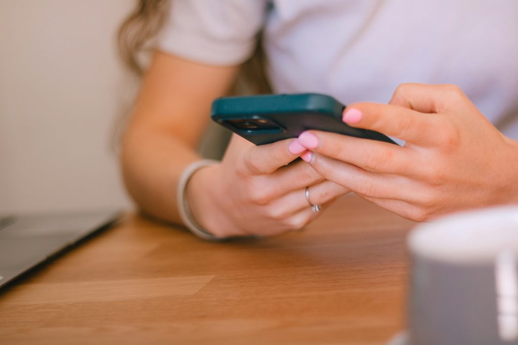 woman holding mobile phone as if texting or sending an email